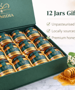 Luxury Numidia gift box containing twelve 500g jars of unpasteurised Lancashire honey arranged in golden packaging, with honeycomb and dipper on a marble surface.