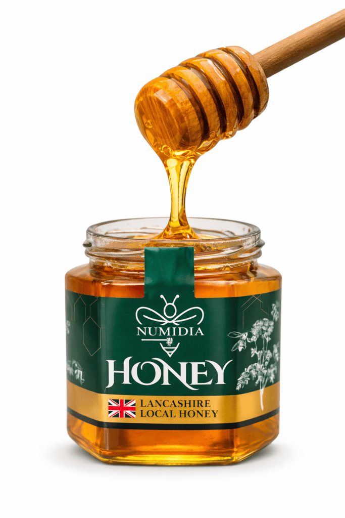 Wooden honey dipper drizzling British honey into a Numidia Lancashire Local Honey jar