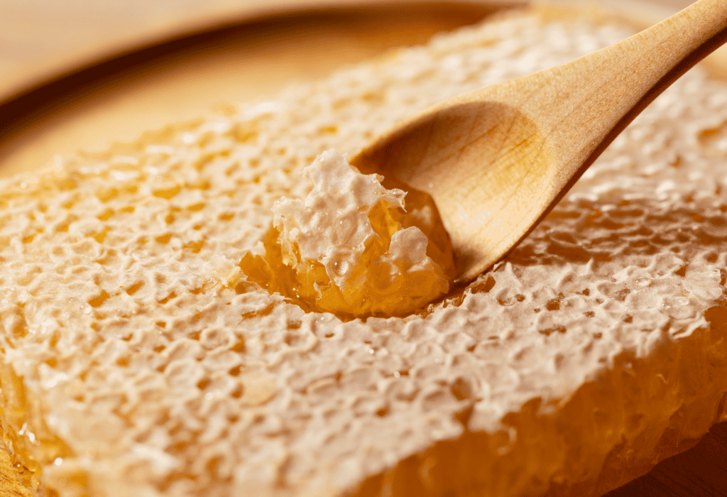 raw pure honey dripping from wooden dipper