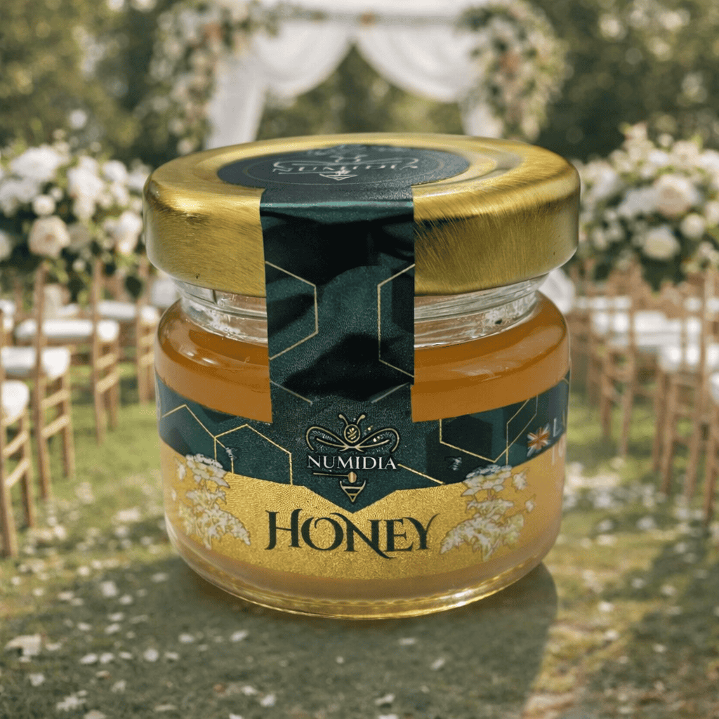 Small honey jars uk by Numidia displayed at a wedding ceremony with elegant floral décor.